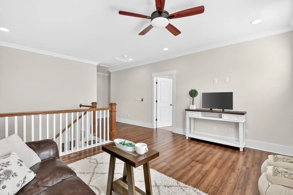 Living area featuring ornamental molding, recessed lighting, wood finished floors, and ceiling fan