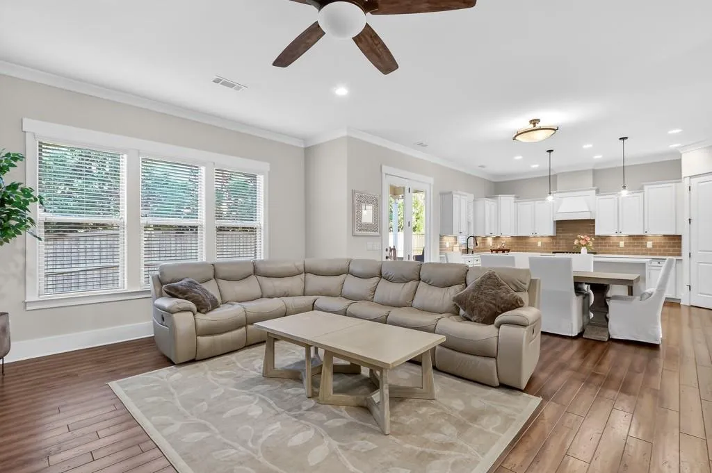 Living area featuring ceiling fan, crown molding, dark wood-style flooring, and recessed lighting