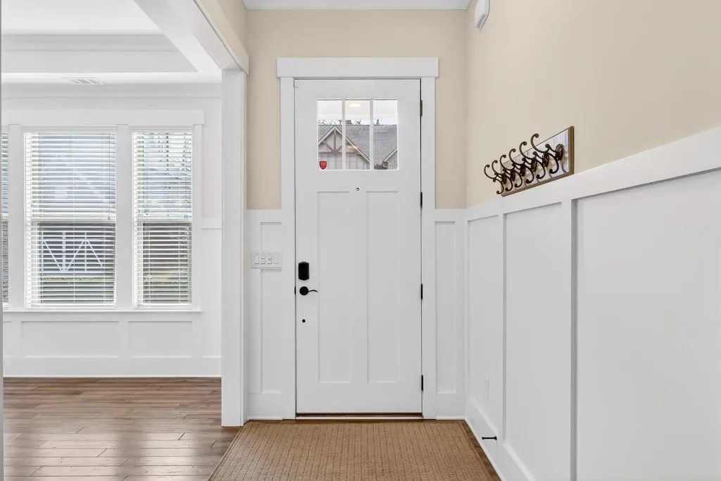Entryway featuring a decorative wall, a wainscoted wall, and wood-type flooring