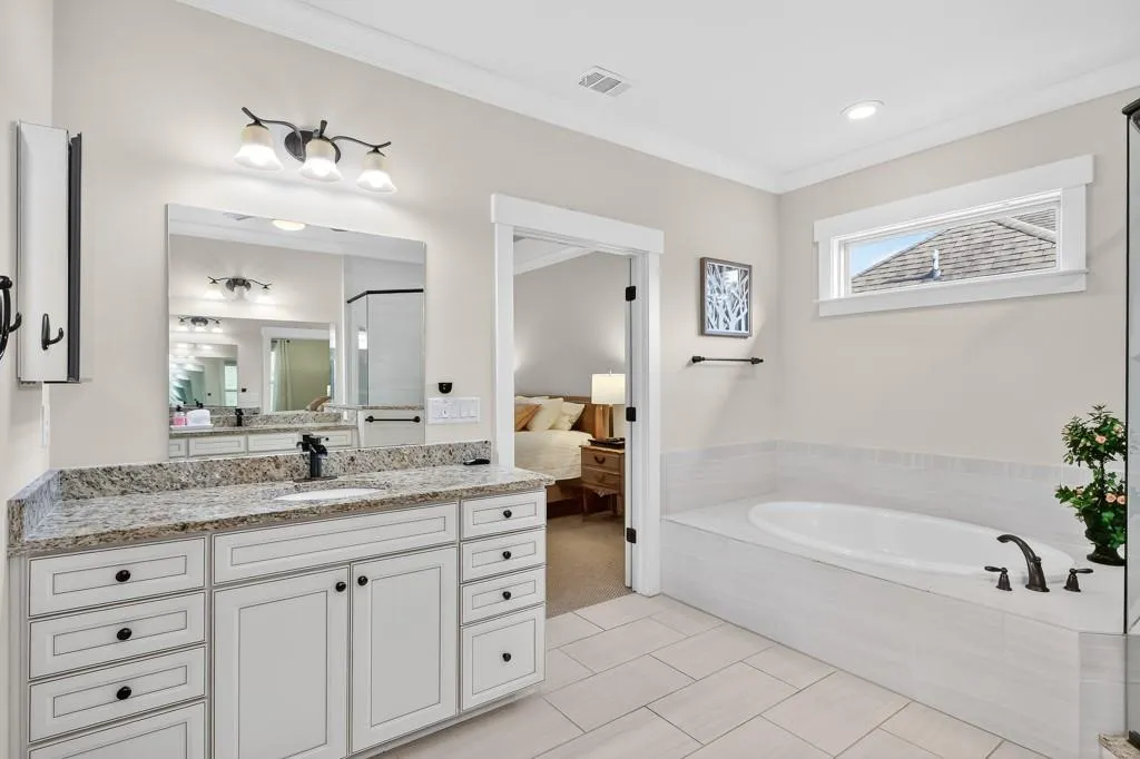 Ensuite bathroom featuring a garden tub, vanity, a shower stall, and ornamental molding
