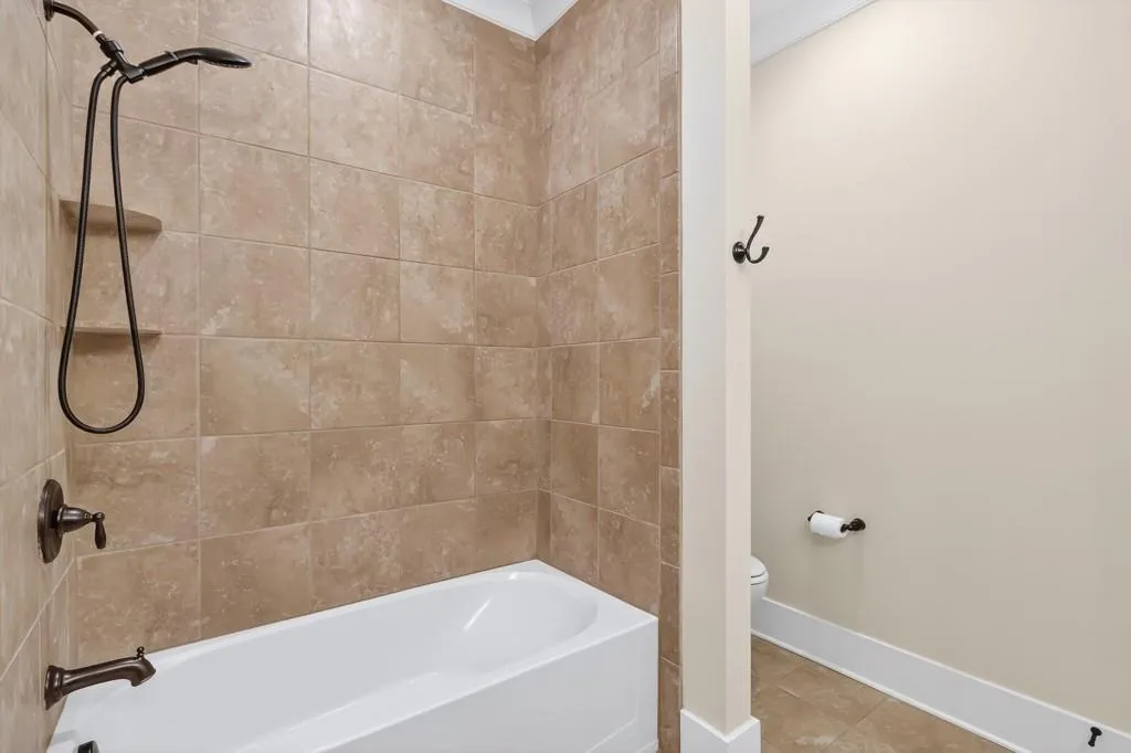 Full bath featuring shower / washtub combination and tile patterned floors