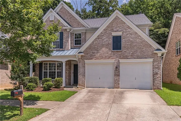 Brick exterior with gabled roof lines, covered front porch, and a two-car garage