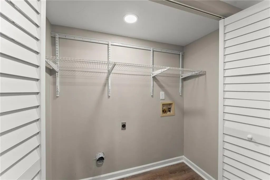 Laundry room with dark wood-type flooring, washer hookup, and electric dryer hookup