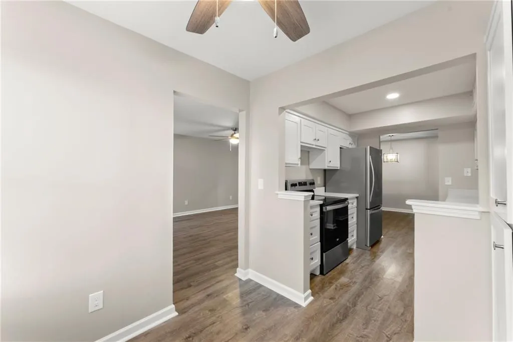 Kitchen with white cabinetry, dark hardwood / wood-style flooring, and stainless steel appliances