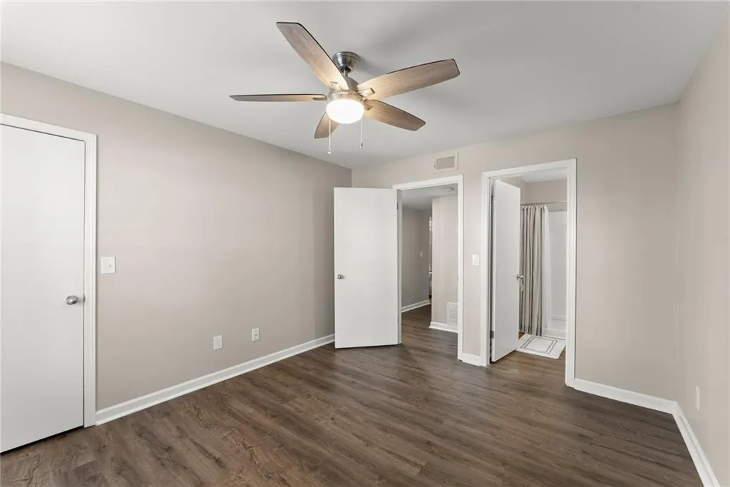 Unfurnished bedroom with ceiling fan and dark hardwood / wood-style flooring