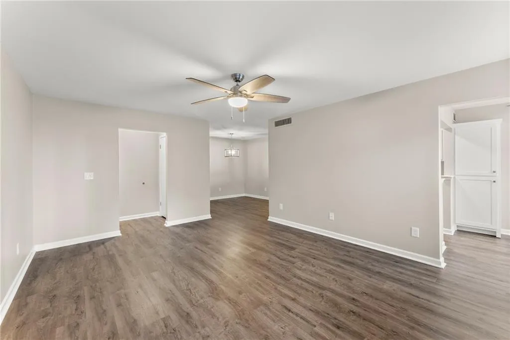 Unfurnished room with ceiling fan and dark hardwood / wood-style flooring