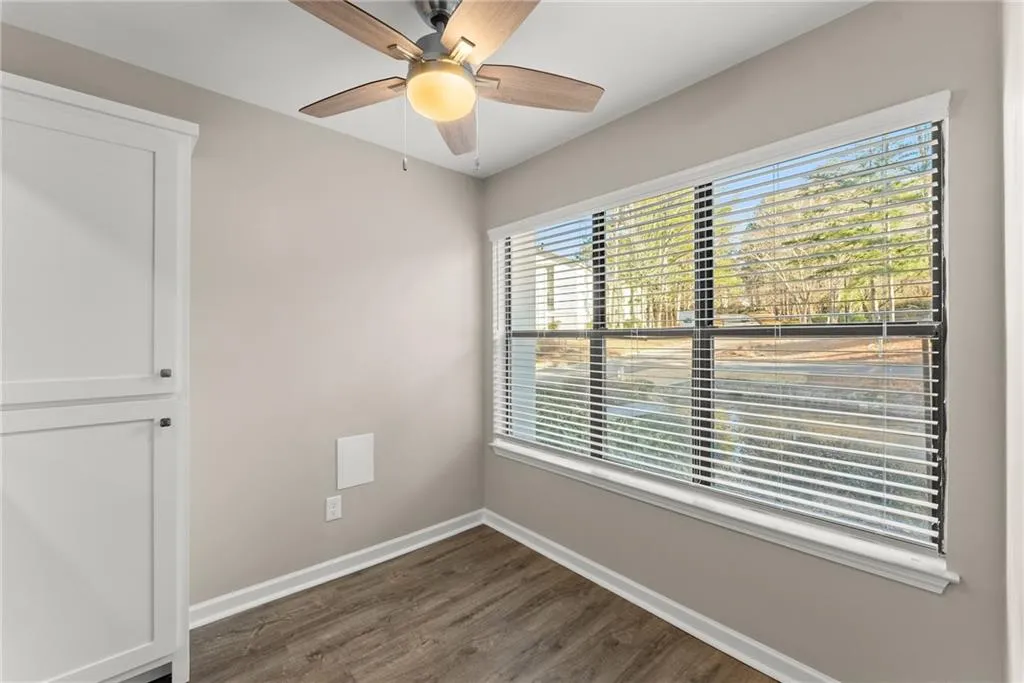 Spare room featuring dark wood-type flooring and ceiling fan