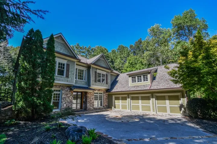 Stone and siding exterior with multiple gables and a multi-car garage