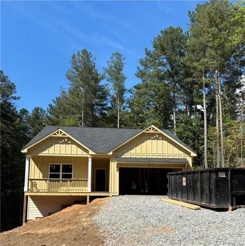 Traditional-style exterior with yellow siding, a dark shingle roof, and an attached garage