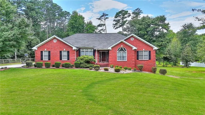 Red brick exterior with dark shutters, arched window detail, and a dark shingle roof