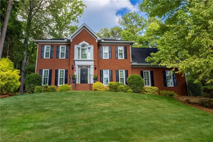 Brick exterior with black shutters and white window frames