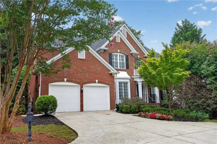 Brick exterior with a gabled roofline, two-car garage, bay window, and a covered porch entry