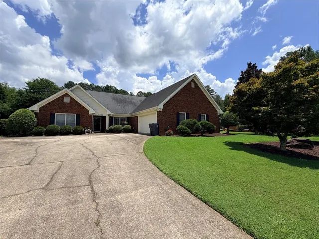 Brick exterior residence with a gabled roofline and an attached garage