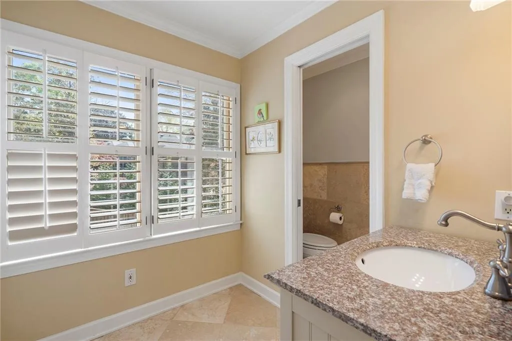 Bathroom featuring crown molding, vanity, and light tile patterned flooring