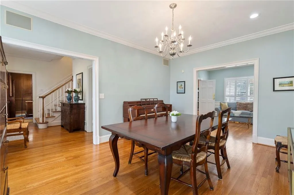 Dining area with light wood-style flooring, ornamental molding, and hanging lights