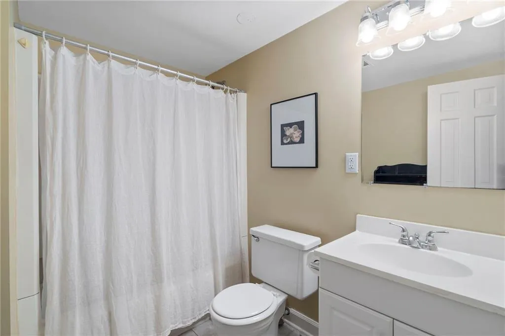 Bathroom with a shower with curtain and vanity