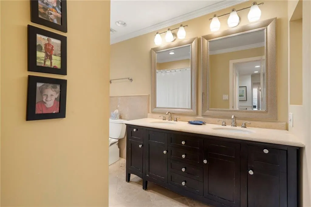 Bathroom with double vanity, ornamental molding, curtained shower, light tile patterned flooring, and recessed lighting