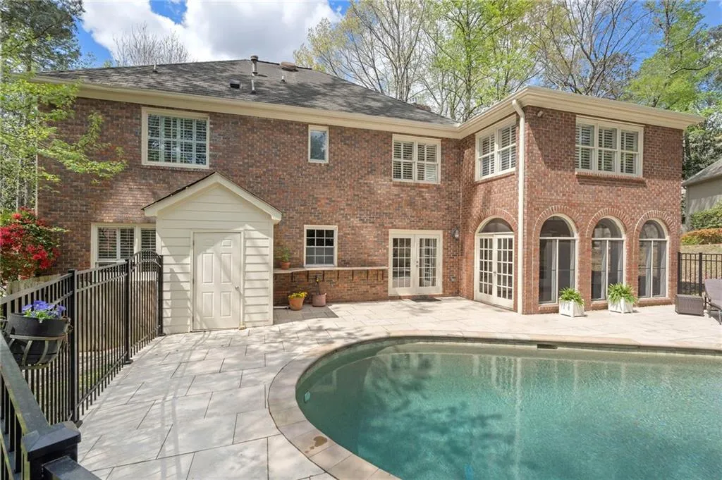 Back of house featuring a patio area, french doors, and brick siding