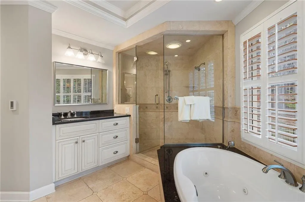 Full bathroom featuring vanity, ornamental molding, a shower stall, a whirlpool tub, and light tile patterned floors