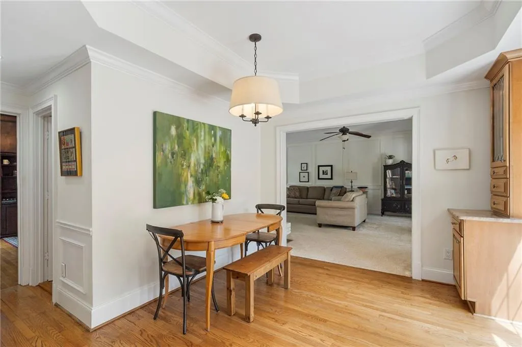 Dining room featuring light wood-style flooring, ornamental molding, and a ceiling fan