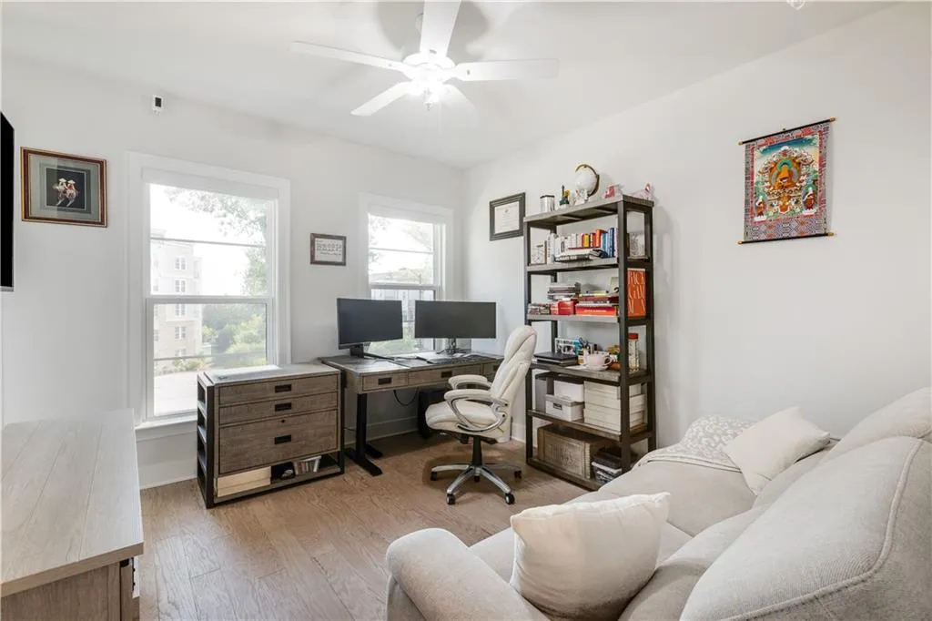 Office space with light wood-type flooring and ceiling fan
