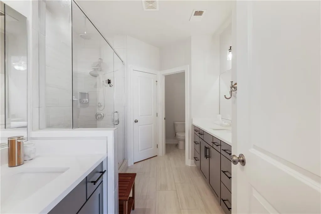 Bathroom with two vanities and a shower stall