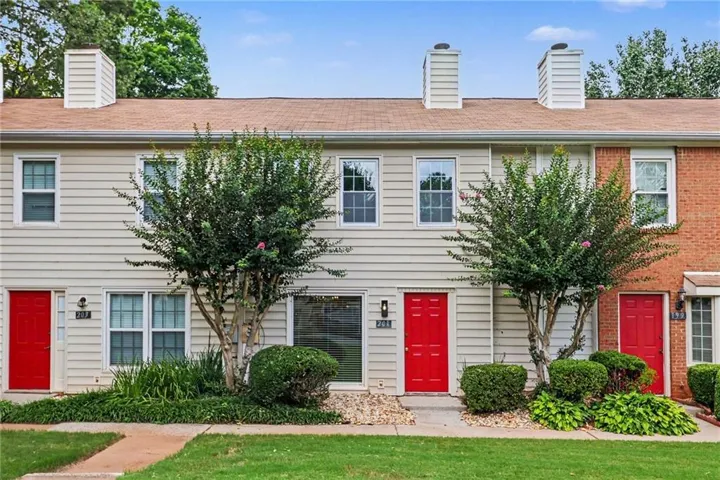 Townhome exterior featuring horizontal siding and red entry doors