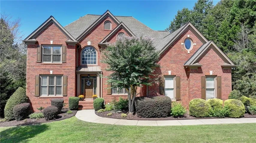 Traditional-style house featuring brick siding and a front yard