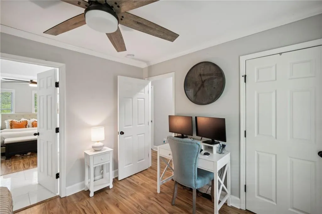 Office space with ornamental molding, light hardwood / wood-style flooring, and ceiling fan