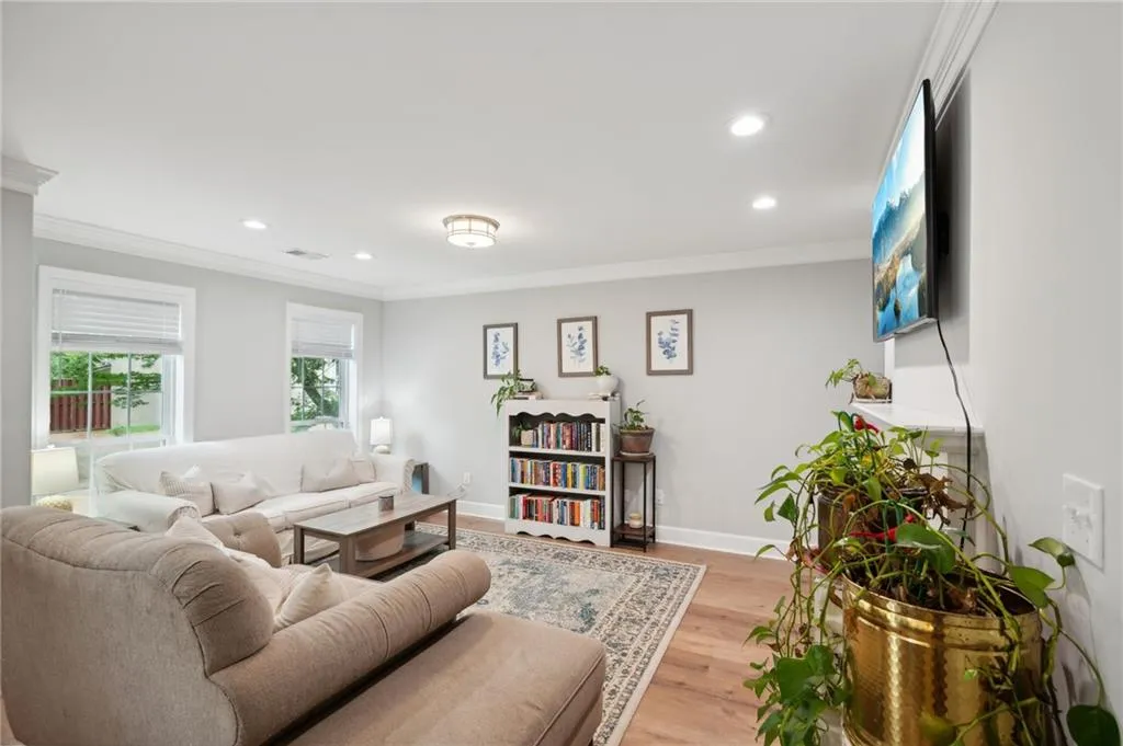 Living room with ornamental molding and hardwood / wood-style flooring