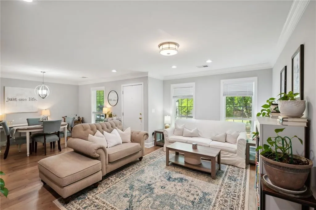 Living room with a chandelier, crown molding, and wood-type flooring