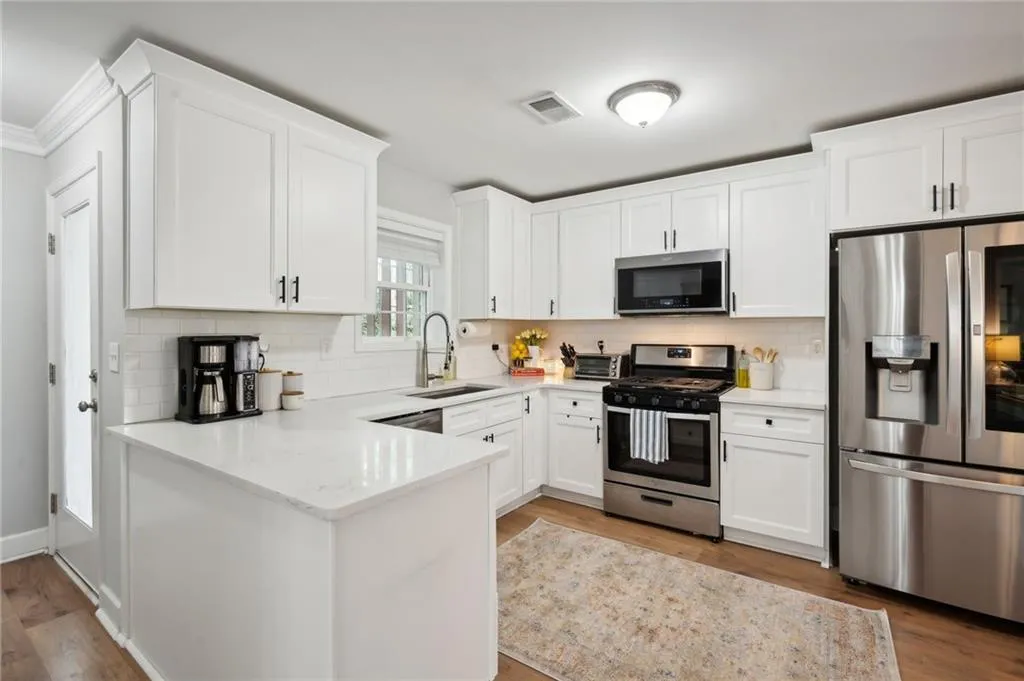 Kitchen featuring backsplash, stainless steel appliances, sink, and light wood-type flooring