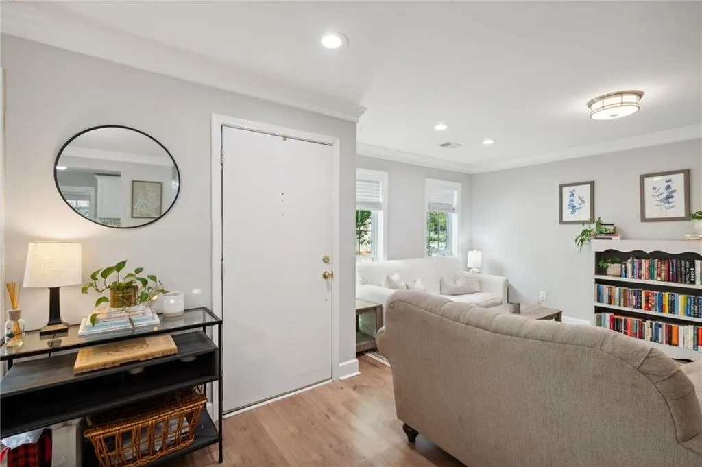 Living room featuring ornamental molding and light hardwood / wood-style floors