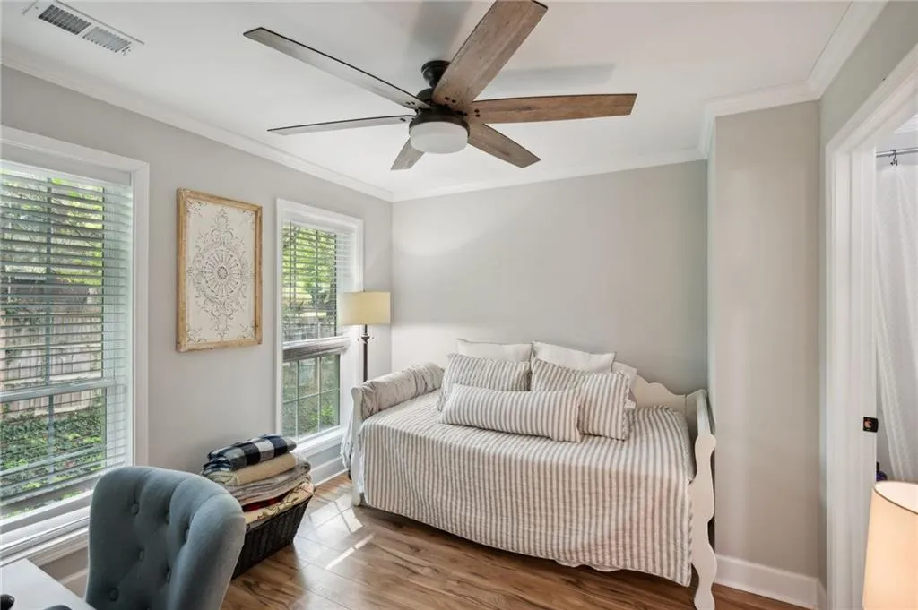 Bedroom with hardwood / wood-style floors, ceiling fan, and crown molding