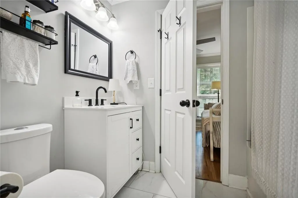 Bathroom featuring large vanity, tile floors, and toilet