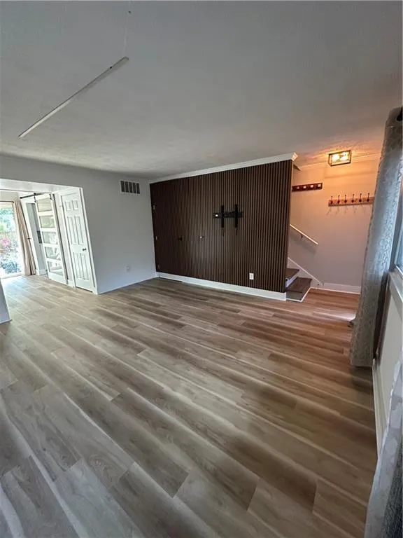 Unfurnished living room with light wood-style flooring and baseboards