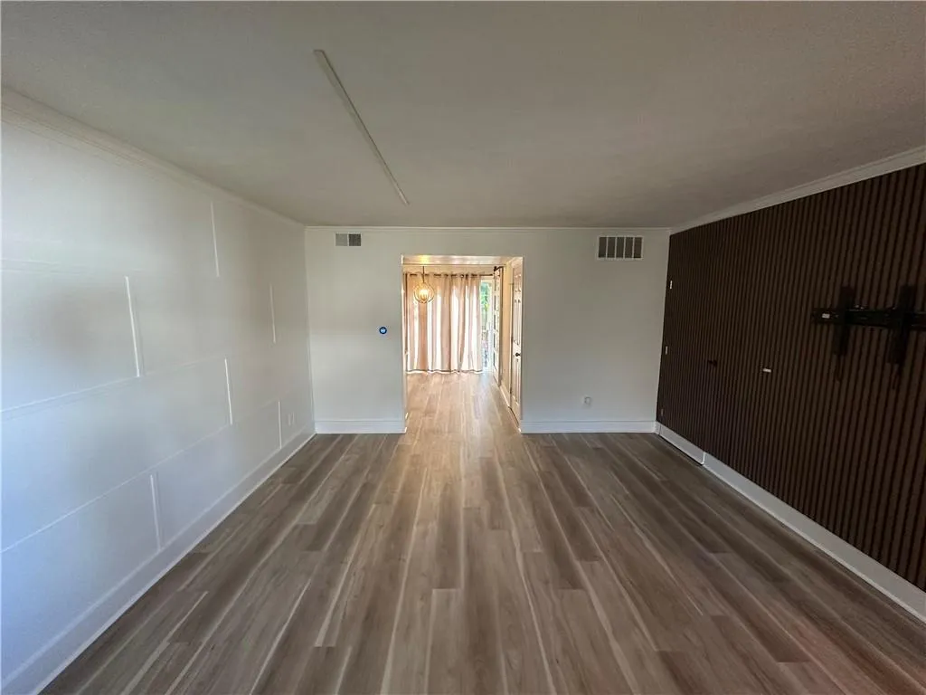 Unfurnished room featuring wood finished floors and crown molding