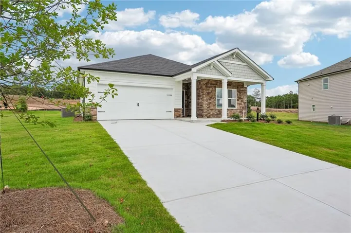 Contemporary single-story residence with a stone and siding facade, featuring a covered front porch with white columns