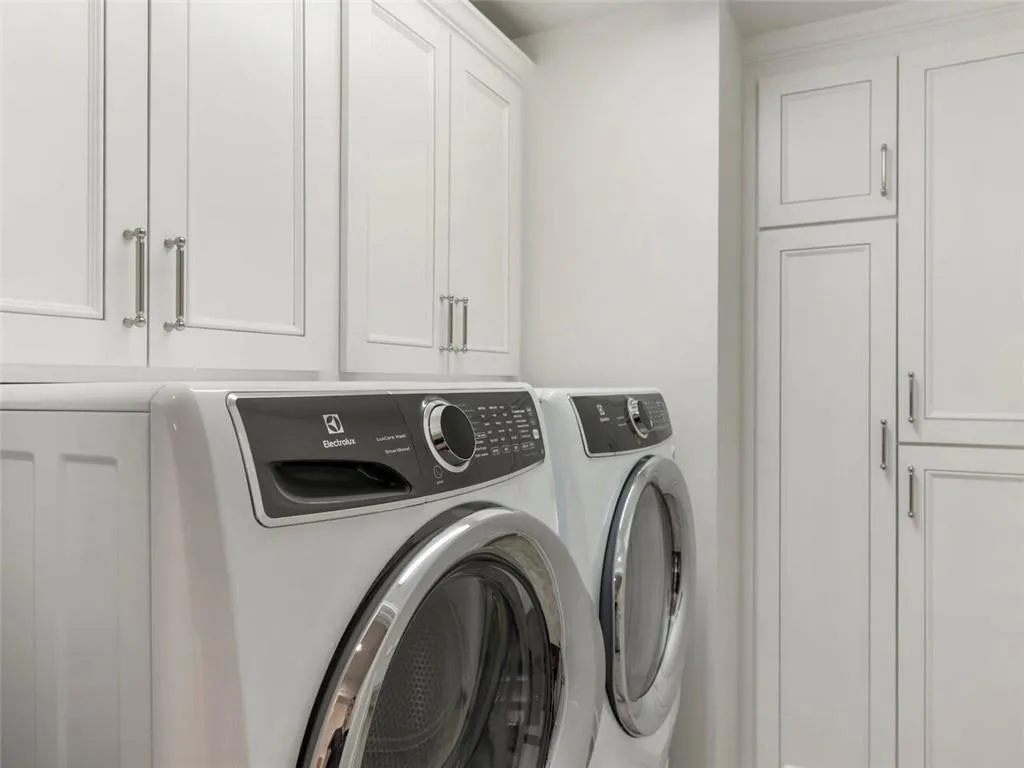 Laundry area featuring washing machine and dryer and cabinets