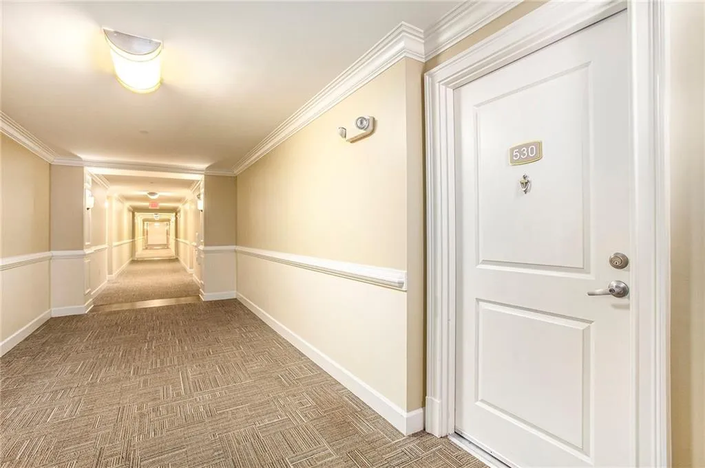 Hallway with ornamental molding and carpet flooring