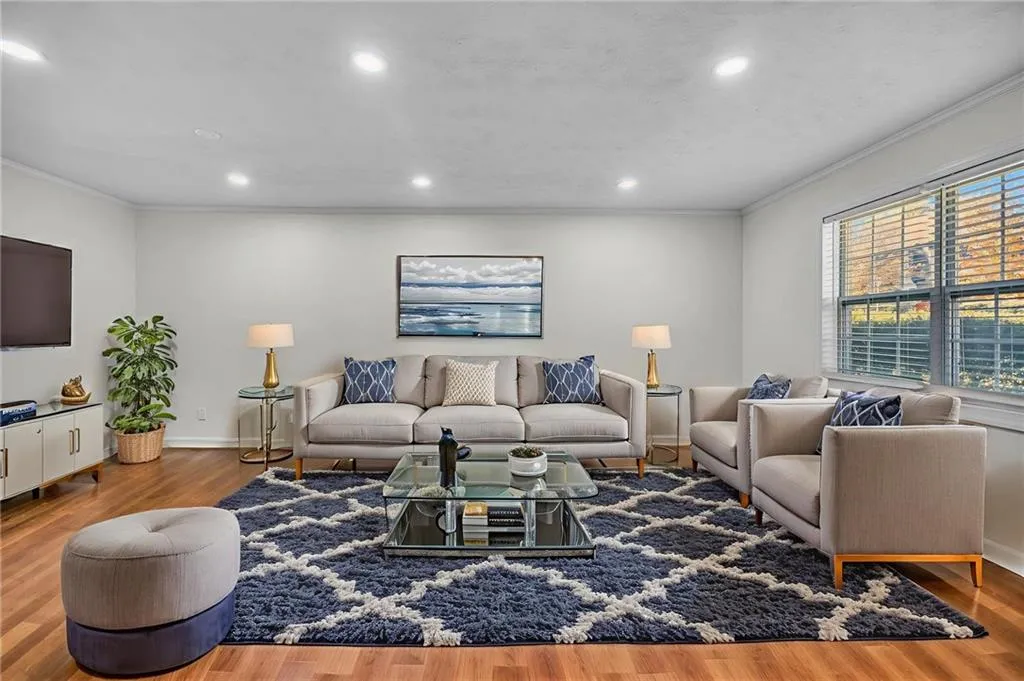 Living room featuring ornamental molding, wood finished floors, and recessed lighting