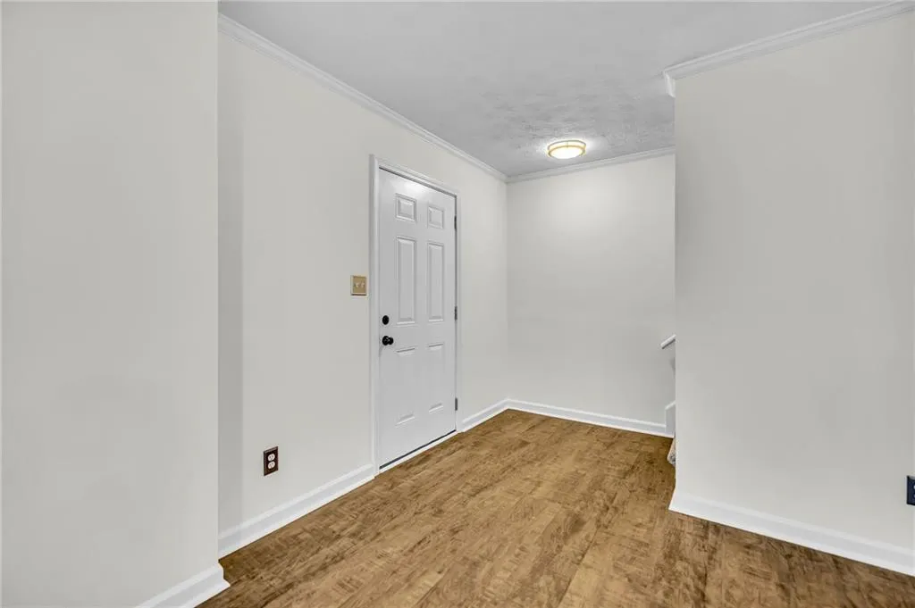 Entryway featuring crown molding and wood finished floors