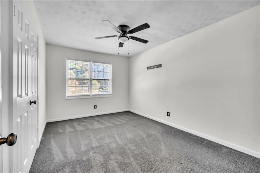Unfurnished bedroom with carpet floors, a ceiling fan, and a textured ceiling