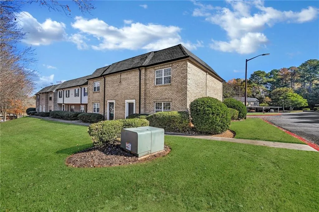 View of property exterior with a yard and brick siding