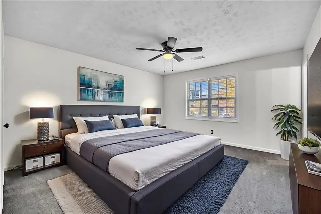 Carpeted bedroom featuring a textured ceiling and ceiling fan