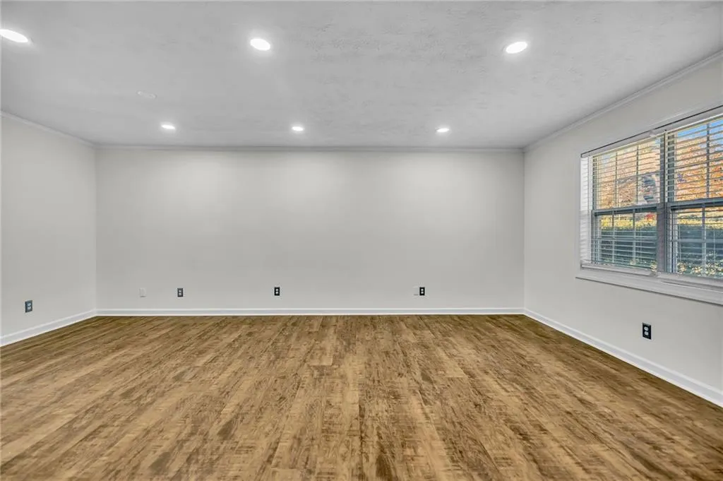 Spare room with ornamental molding, wood finished floors, recessed lighting, and a textured ceiling