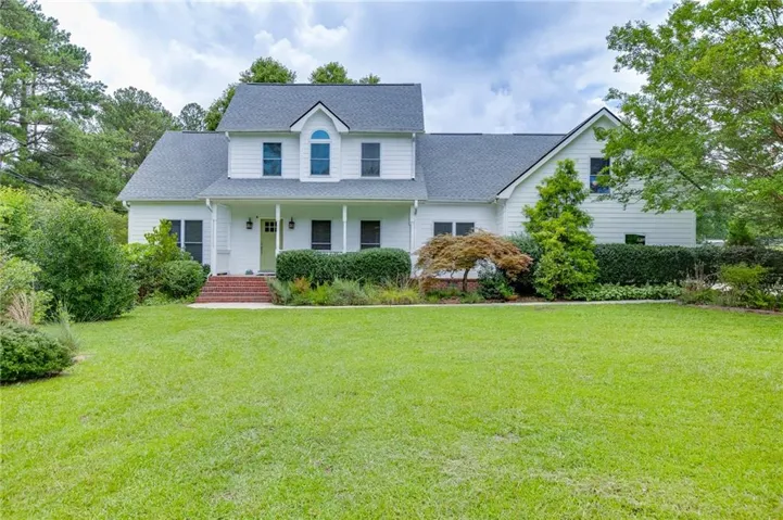 Welcoming Southern-style home with a charming covered front porch and beautifully landscaped yard.