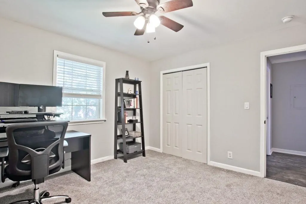 Home office featuring light colored carpet and a ceiling fan