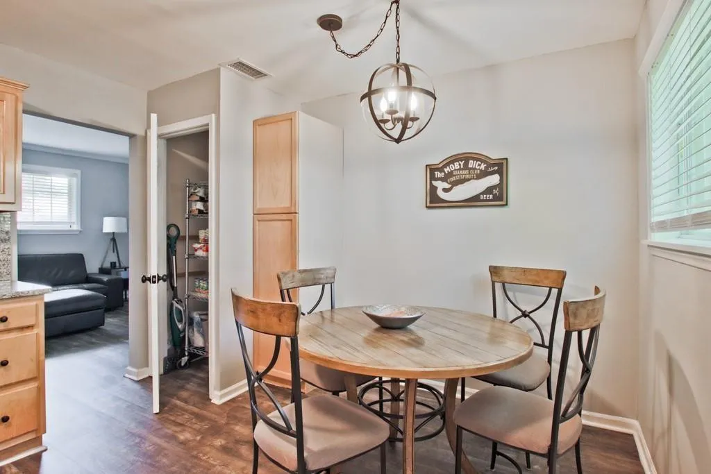 Dining room featuring dark wood-type flooring and a chandelier