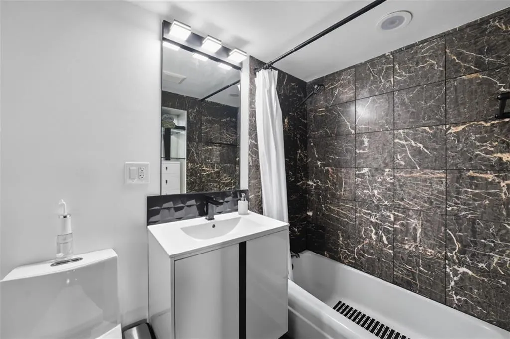 Full bathroom featuring shower / bathtub combination with curtain and vanity